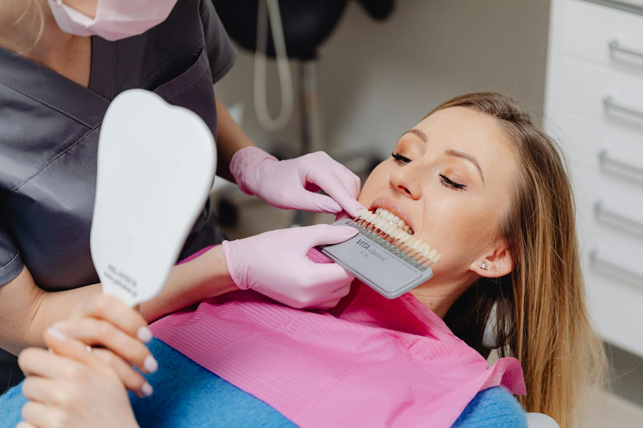 Dentist comparing teeth shades for veneers or Lumineers