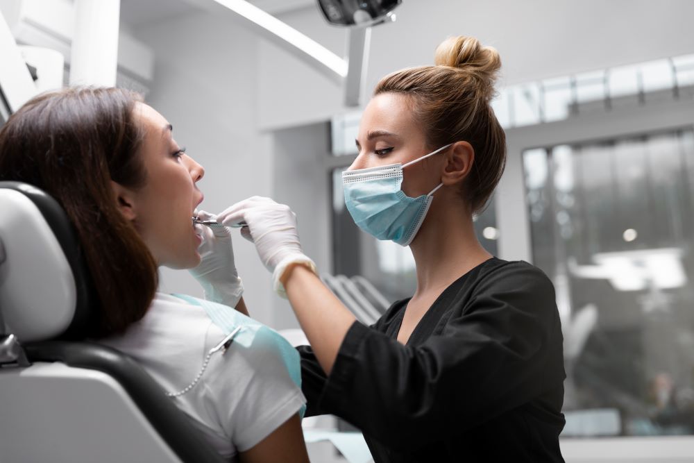 Dentista realizando un examen de higiene dental de rutina para prevenir la enfermedad de las encías.